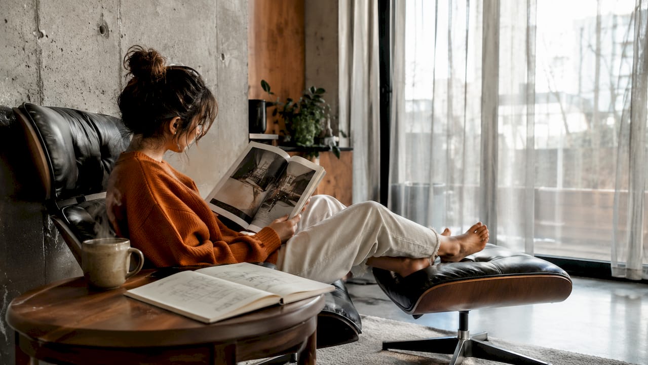 Woman reading in industrial living room