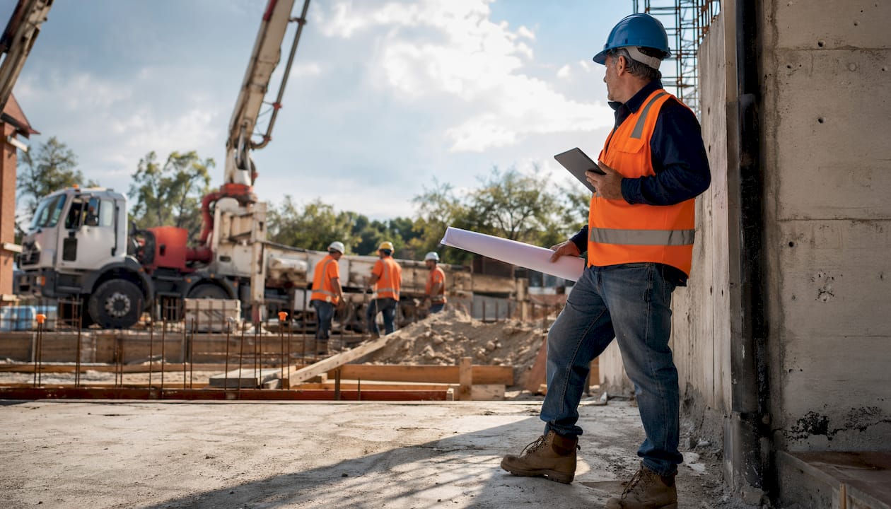 Construction manager reviewing concrete placement plan onsite