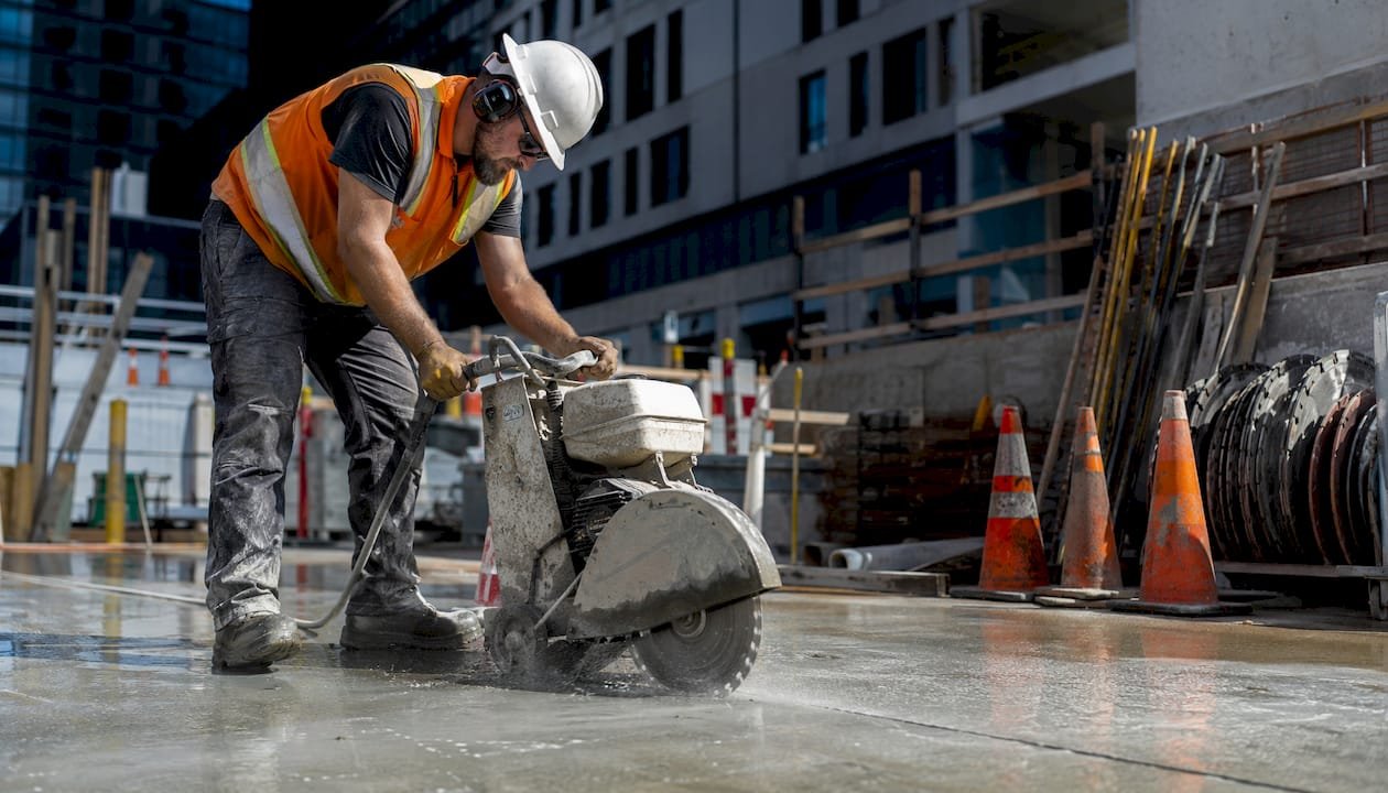Construction worker cutting concrete slab