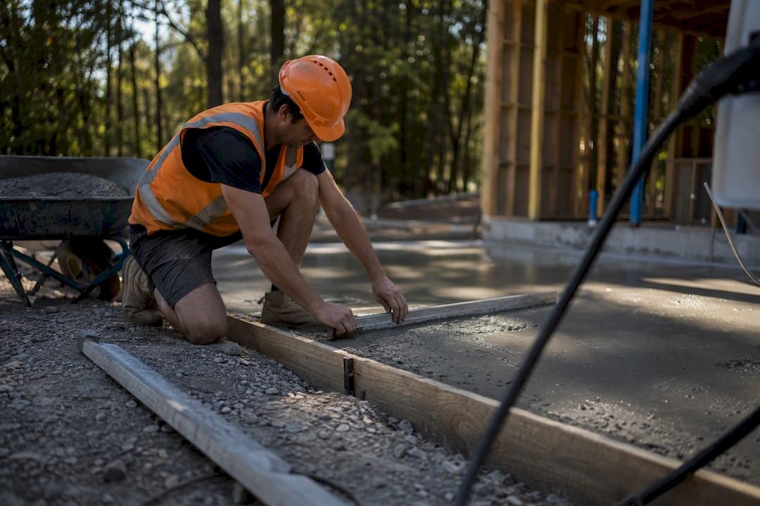 Worker leveling fresh concrete garage slab