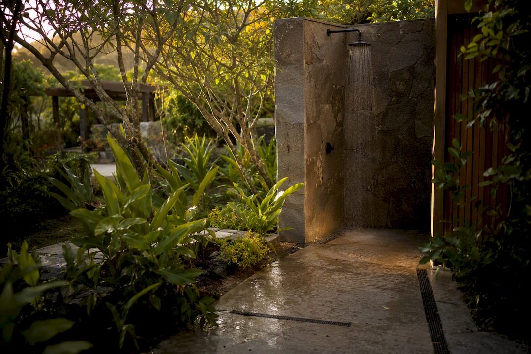 Outdoor bathroom with concrete slab and stone walls