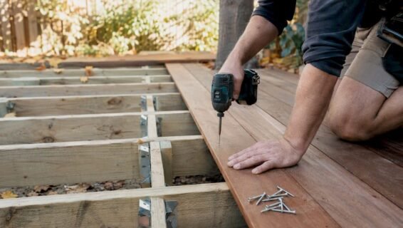 Hands installing timber deck boards