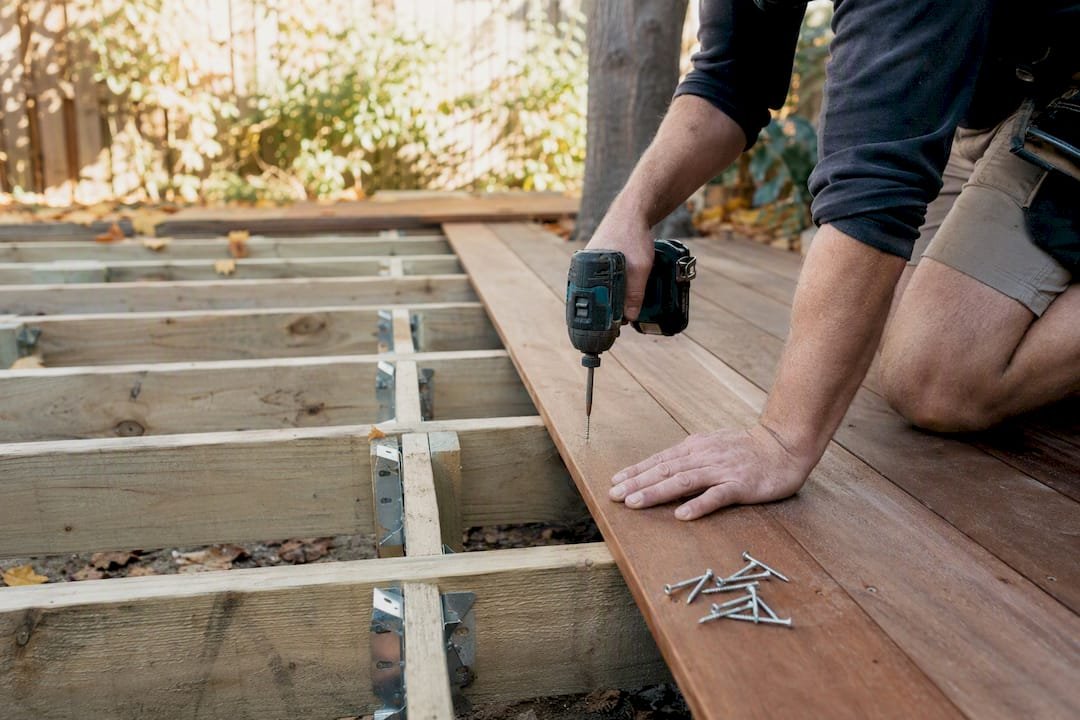 Hands installing timber deck boards