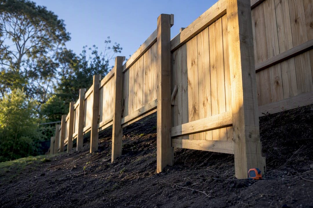 Stepped timber fence climbing a backyard slope